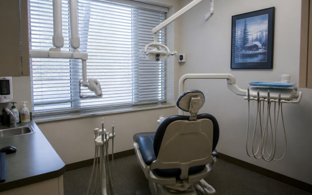 Modern dental chair and operatory equipment in a bright dental office