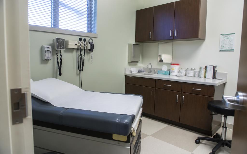 Medical exam room with examination table and wall-mounted diagnostic display